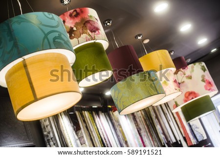 The green fabric lampshade at the magazine. colorful, decorative, electrical, furniture, illumination, lamp, lampshade, style, textile, abstract background, hanging lamp, interior design Royalty-Free Stock Photo #589191521