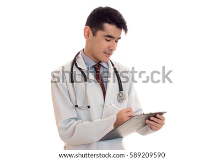 handsome young man doctor in uniform with stethoscop on his neck make notes isolated on white background