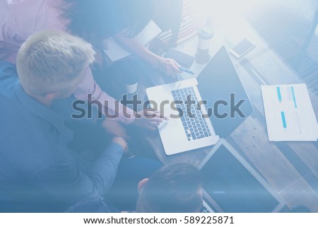 Top view of young team of coworkers making great work discussion in modern office.Man discussing with colleagues stratup project.Business people meeting concept.Visual effects, blurred background