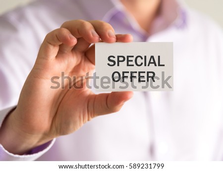 Closeup on businessman holding a card with SPECIAL OFFER message, business concept image with soft focus background and vintage tone