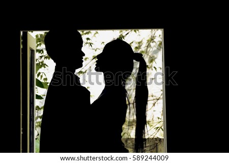 Abstract Couple silhouette in love stand and hug girlfriend by the window.Give me a kiss .It seriously in love relationship.Time to married The Lovers concept.