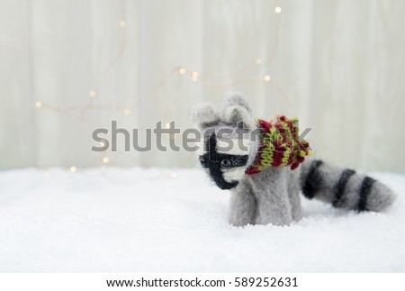 Felt Raccoon Ornament on Snow with subtle bokeh background