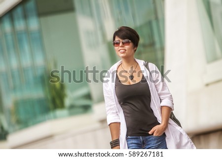 outdoor portrait of young happy smiling woman on urban city background