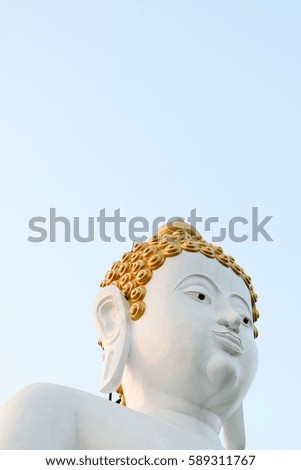 Thai buddha statue isolated with light blue sky background.