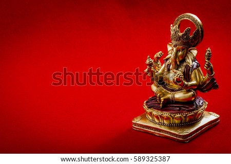 Hindu religion and Indian celebration of Diwali festival concept with the Lord Ganesha on red background and copy space. Ganesha is the patron of arts and sciences and the deva of intellect and wisdom