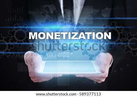 Businessman holding tablet PC with monetization concept.