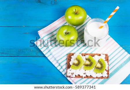 Healthy eating. Toast with cottage cheese and slices of kiwi, juicy green apples and home yogurt without sugar.  Copy space.
