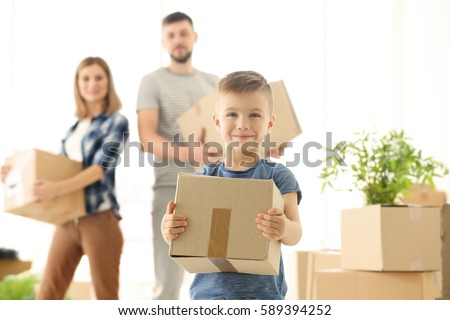 Happy boy with box on blurred background. Moving concept