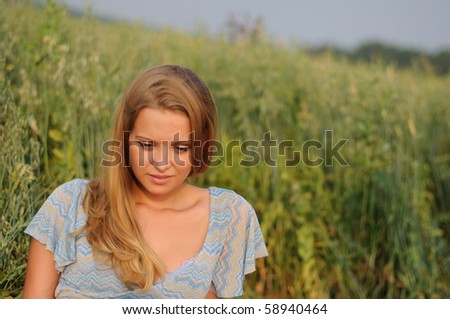 Young girl on a background of green grass and blue sky