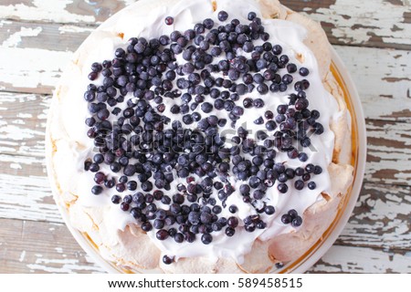 meringue cake with cream decorated with blueberries