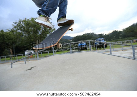 young skateboarder legs practice ollie at skatepark ramp