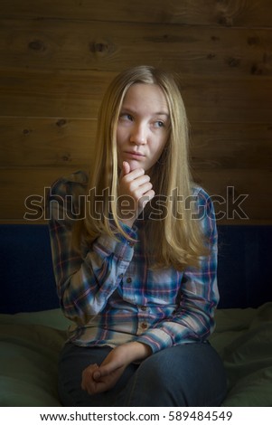 Low-key portrait. Long-haired teenager girl pensive blonde.