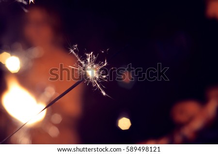 festive sparklers burn at the festival on the background of people

