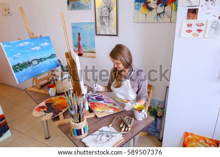 Charming Young Woman Artist Draws Oil Painting With Purple Flowers on a White Canvas, Female Enjoying Favorite Work, Hobbies, posing  for camera and Painting Picture to Order or Gift. Woman With Lon