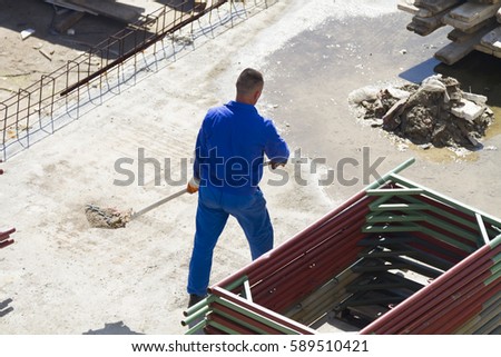Photo of the Worker works with a shovel, cleaning rubble