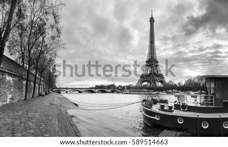 Beautiful panoramic view of the Eiffel Tower and Jena bridge from the river Seine embankment. Dramatic cloudscape. BW photography. Paris, France.