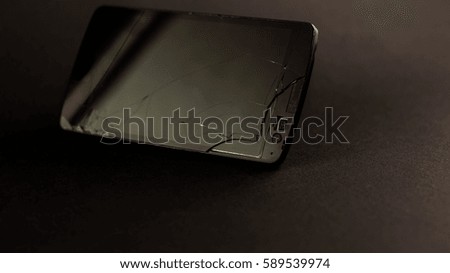 Broken smartphone on a black background