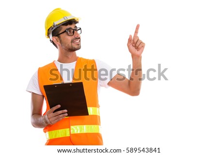 Thoughtful happy Persian man construction worker smiling and holding clipboard while pointing finger up