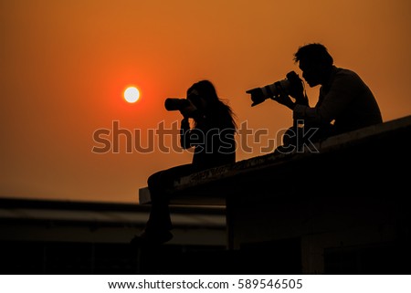 photographer silhouette.,Silhouette of Love Couple like to travel and photographer, taking pictures of the beautiful moments during the sunset,silhouette of a photographer who shoots a sunset in city