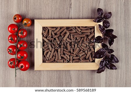 Ingredients Italian pasta in wood frame on beige wooden board  as decorative picture background. Mock up restaurant menu.