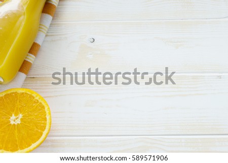 Bottle of orange juice from above on white wood table. Empty ready for your orange juice, fruit product display or montage.