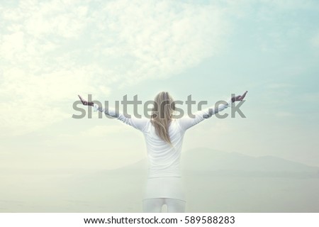 woman takes a breath in front of a blue sky Royalty-Free Stock Photo #589588283