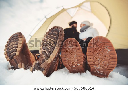 sole of winter shoes. Man and woman in camping tent Royalty-Free Stock Photo #589588514