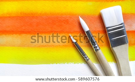 Color bright watercolor background with set of paintbrushes
