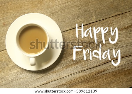 A cup of coffee with HAPPY FRIDAY written on a wooden table.