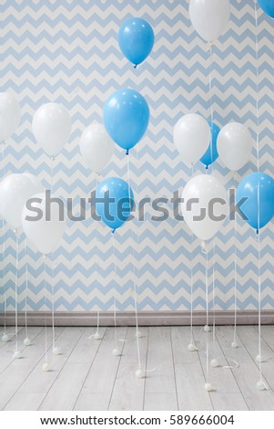 White and blue balloons on the light background of the Wallpaper. Preparing for the holiday