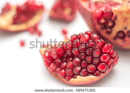 Broken pomegranate on a white background closeup with strong blur
