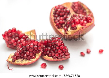 Broken pomegranate on a white background closeup with strong blur