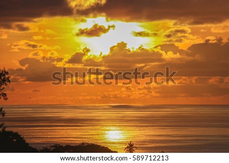 The sun sets in the ocean water. View from the coast