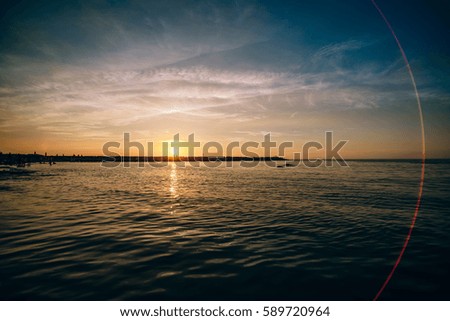 Sunset / sunrise with clouds and sea, light rays and other atmospheric effect