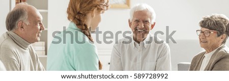 Group of happy patients at nursing home and young nurse