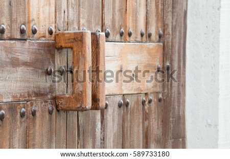 Simple wooden door handle,Old vintage wooden door frame with wooden handle in countryside 