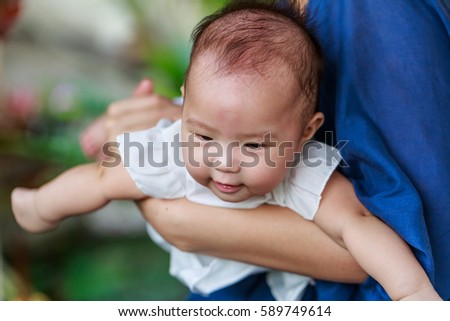Happy infant baby girl on her mother hand