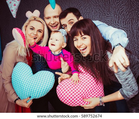 Hearts hang around two young couples posing with little girl