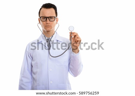 Studio shot of young handsome man doctor using stethoscope