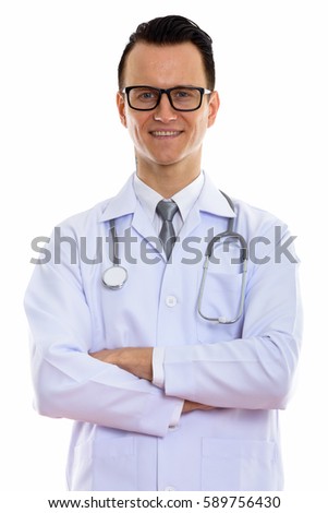 Studio shot of young happy man doctor smiling with arms crossed