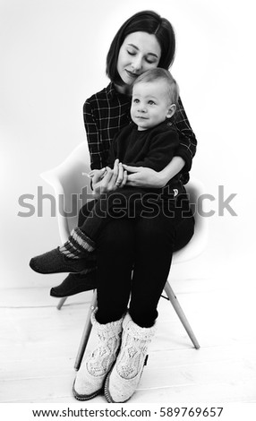 Black and white picture of young mother hugging her little son