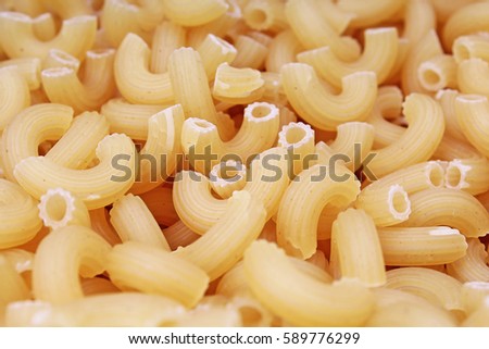 Macaroni  dry pasta background concept. Pasta texture for background uses. Swirled pasta pattern. Food photography in studio.
