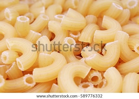 Macaroni  dry pasta background concept. Pasta texture for background uses. Swirled pasta pattern. Food photography in studio.

