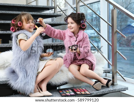 Cute funny girls playing with cosmetics at home