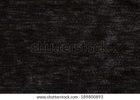Black fluffy background of soft, fleecy cloth. Texture of textile closeup