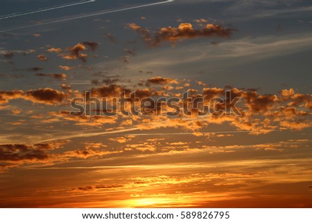 Stunning sunset picture of interesting cloudy sky, golden sun, color gradient blue grey orange, airplanes, vapor trails, made in France, Atlantic coast