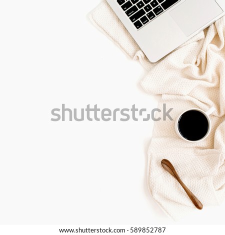 Workspace with laptop, coffee, spoon, white flowers and beige textile on white background. Flat lay. Top view office table desk. 