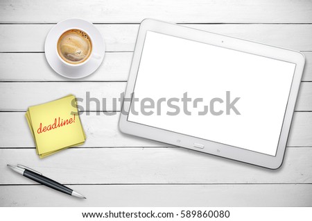Workplace with tablet and cup of coffee on black table.