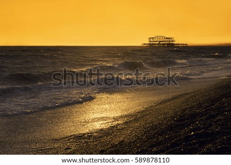 West Pier with waves at sunset, Brighton, England, UK