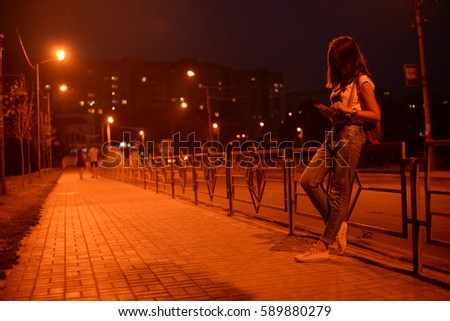 girl on the background of night city, sidewalk, lights, car